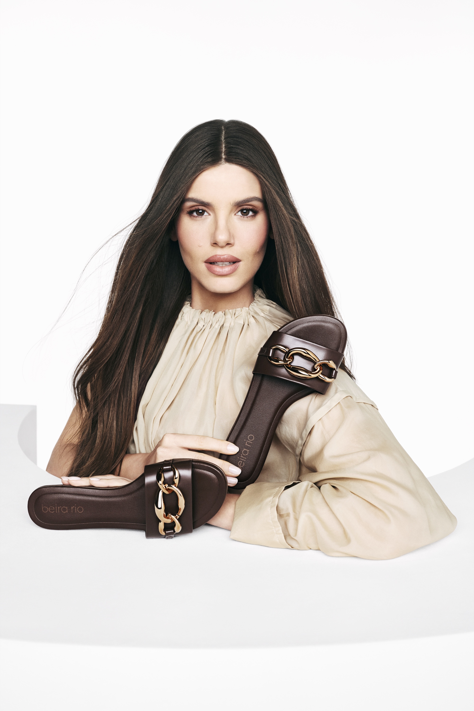 Beira Rio model holding brown sandals